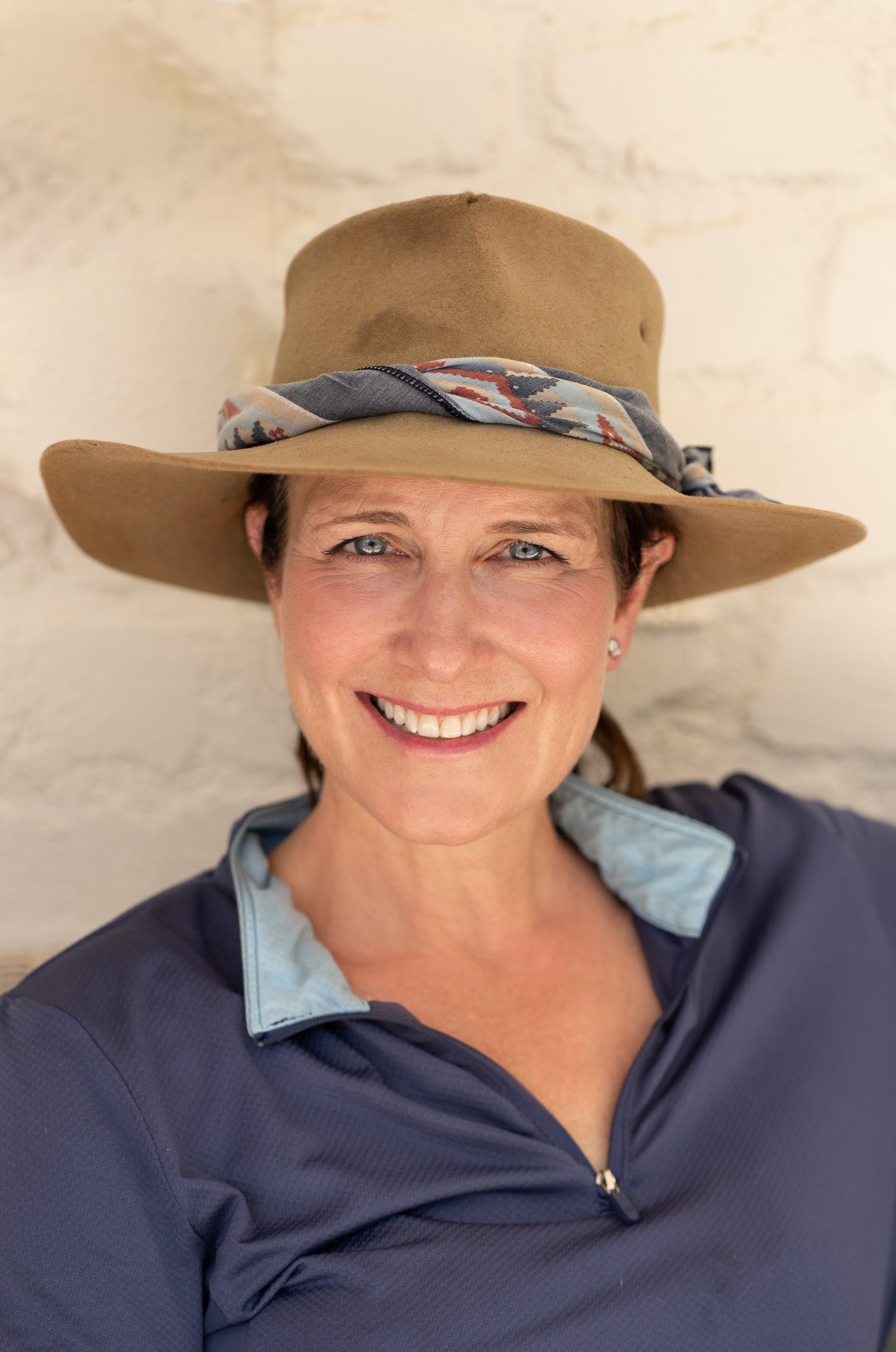 portraits of a blue-eyed woman wearing a hat and a blue shirt