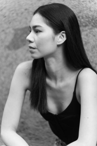 profile shot of an Asian model as she sits and poses for her portraits are being taken
