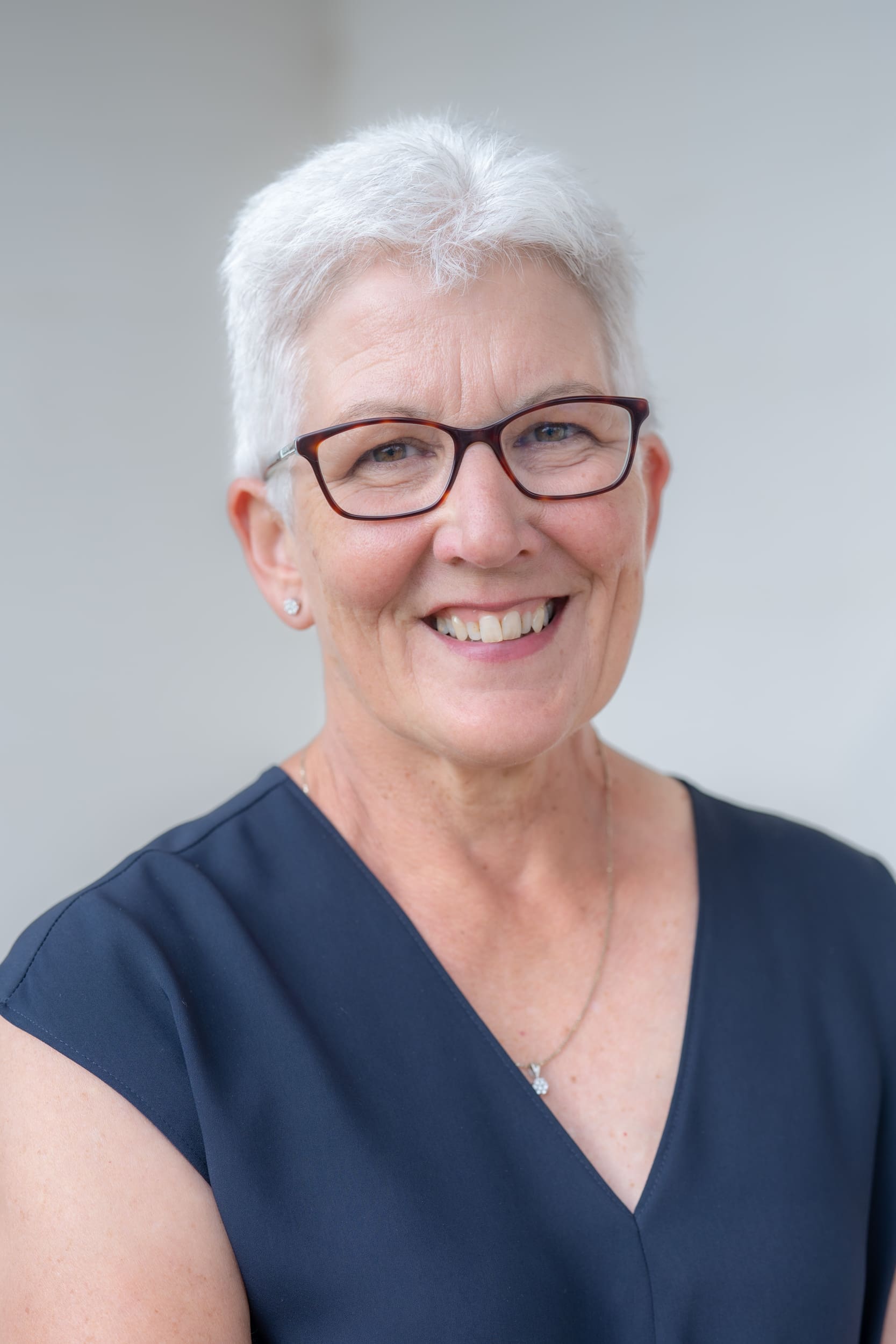 Ext: Older white-haired woman in blue having a high-quality headshot taken by professional photographer Georgie Greene in Sydney NSW