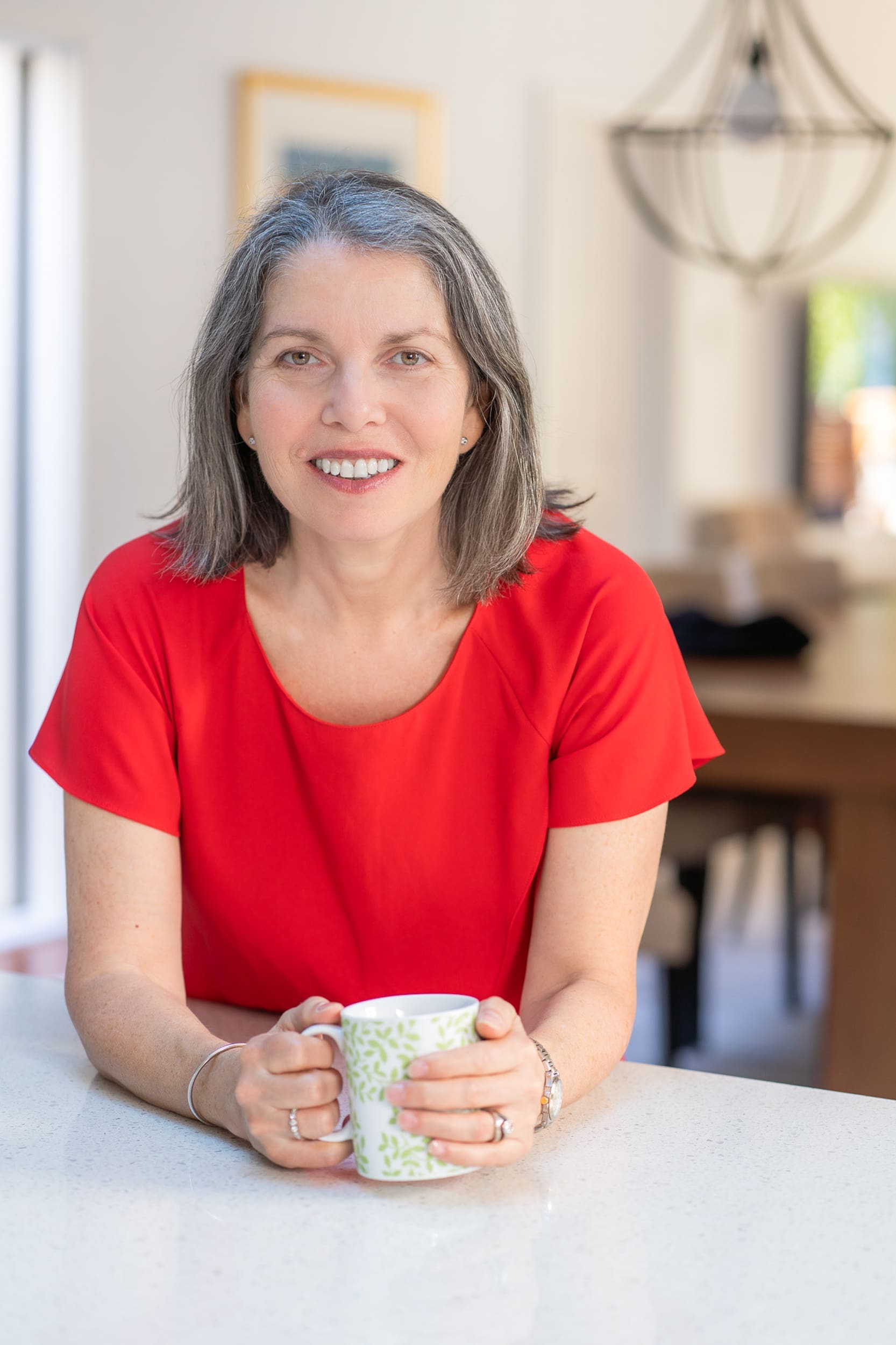 Int: Leadership coach/author wearing a red top having portrait shots taken by personal branding photographer Georgie Greene in Sydney NSW