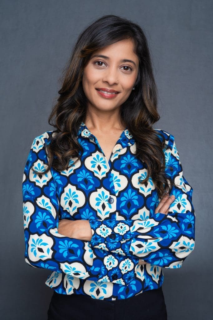 Int: Young Indian woman wearing a blue skirt having LinkedIn headshot taken by Professional Photographer Georgie Greene in Sydney NSW
