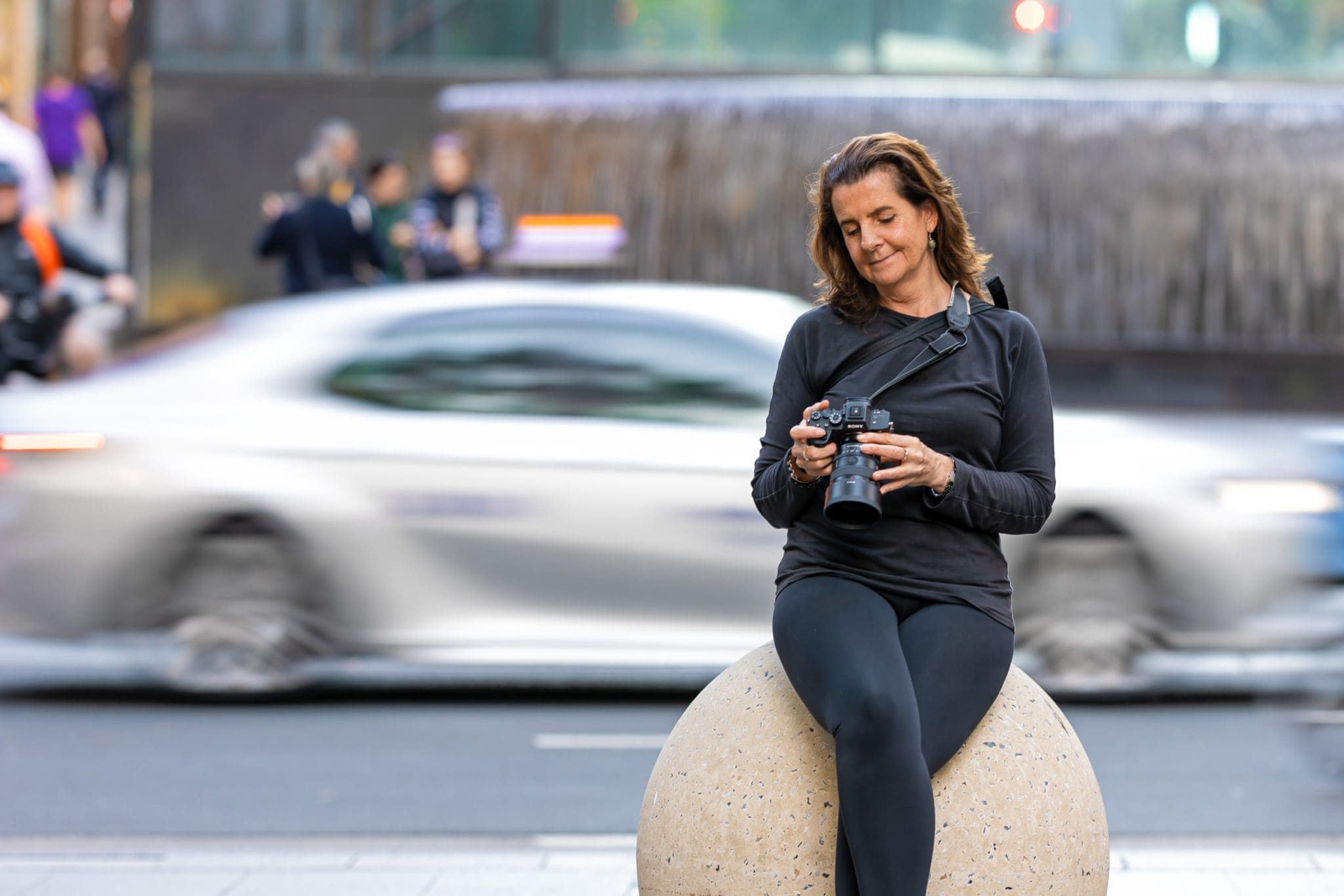 Georgie Greene Headshots and Personal Branding photographer looking at her camera in a Sydney Street