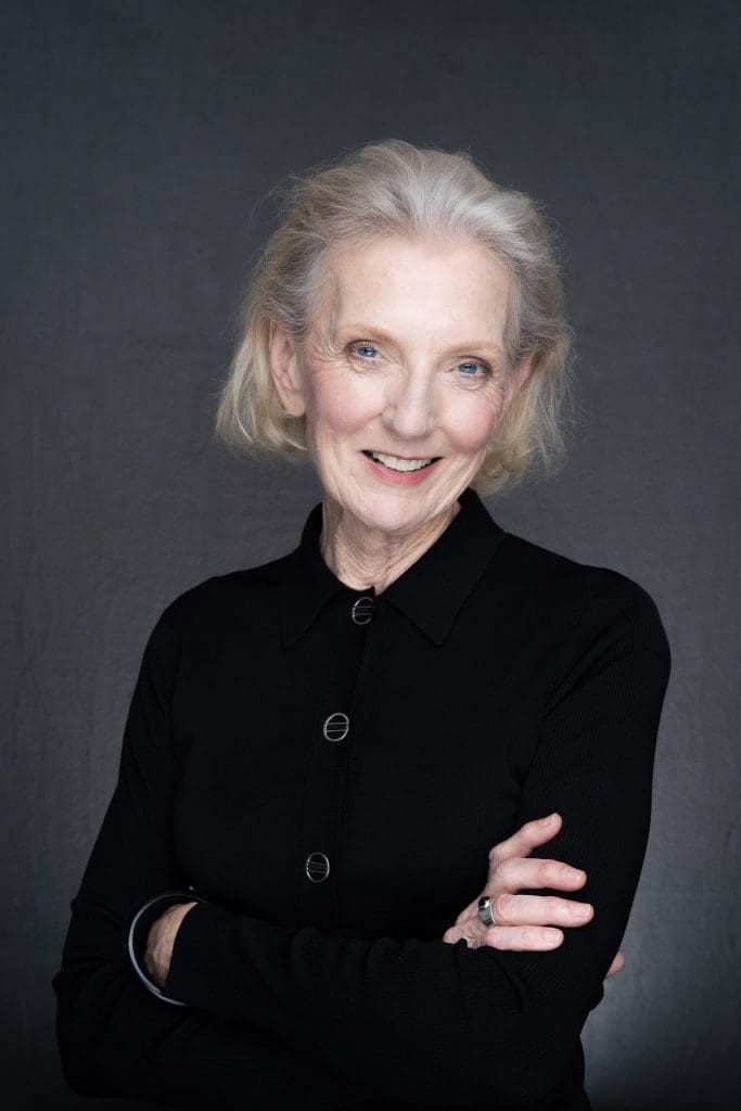 Journalist Helen Trinca wearing a black suite having her headshot taken by professional photographer Georgie Greene in Sydney NSW