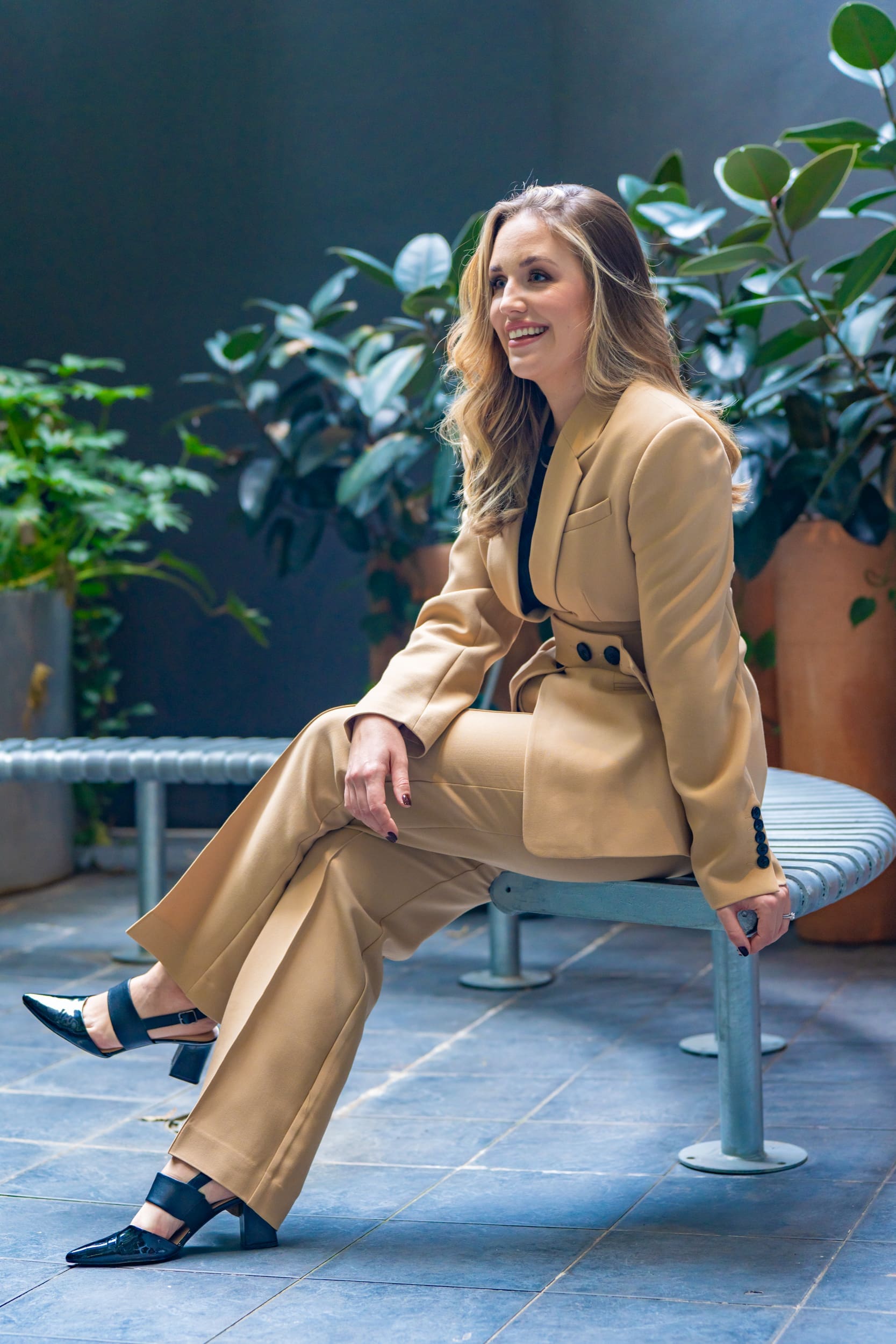 Ext: Managing director wearing a fawn suite having her portrait taken by professional photographer Georgie Greene in Sydney NSW