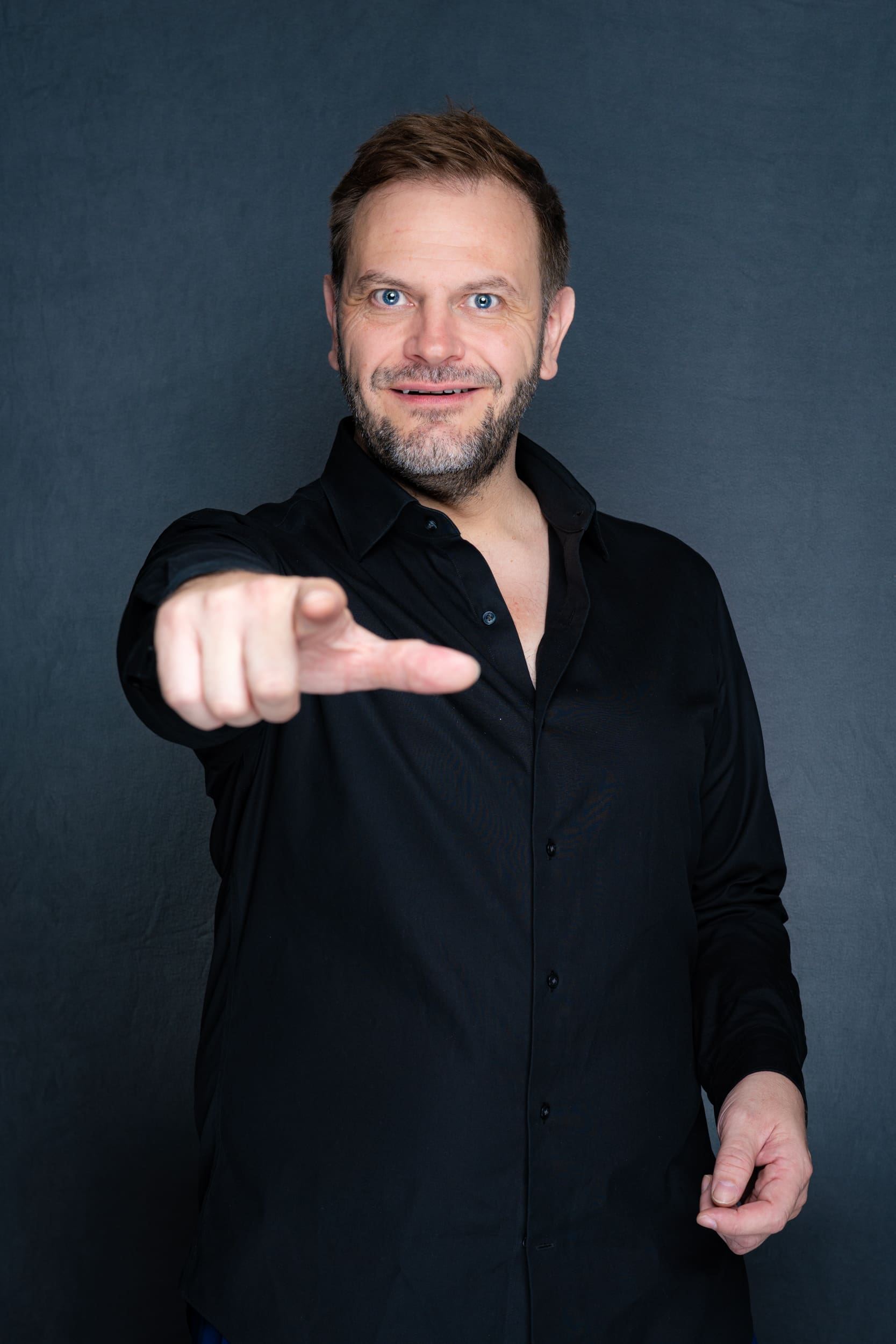 Int: Stand-up Comedian in a black shirt against a grey backdrop Personal Portrait Photos Sydney NSW