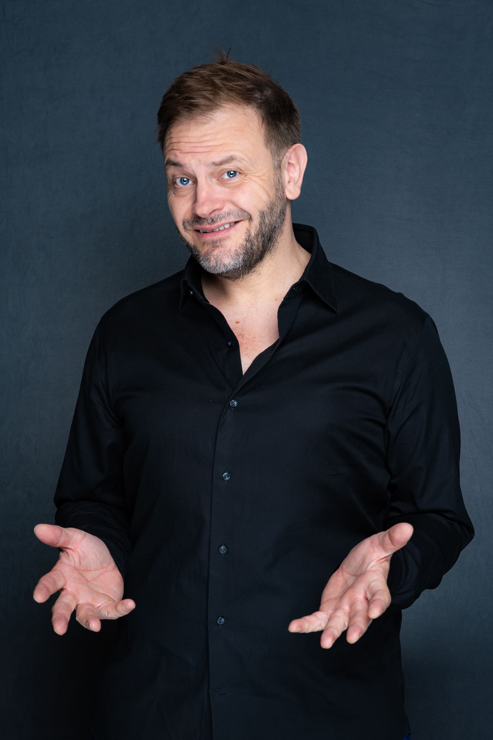 Int: Stand-up Comedic in a black shirt against a grey backdrop Personal Photoshoot Sydney NSW