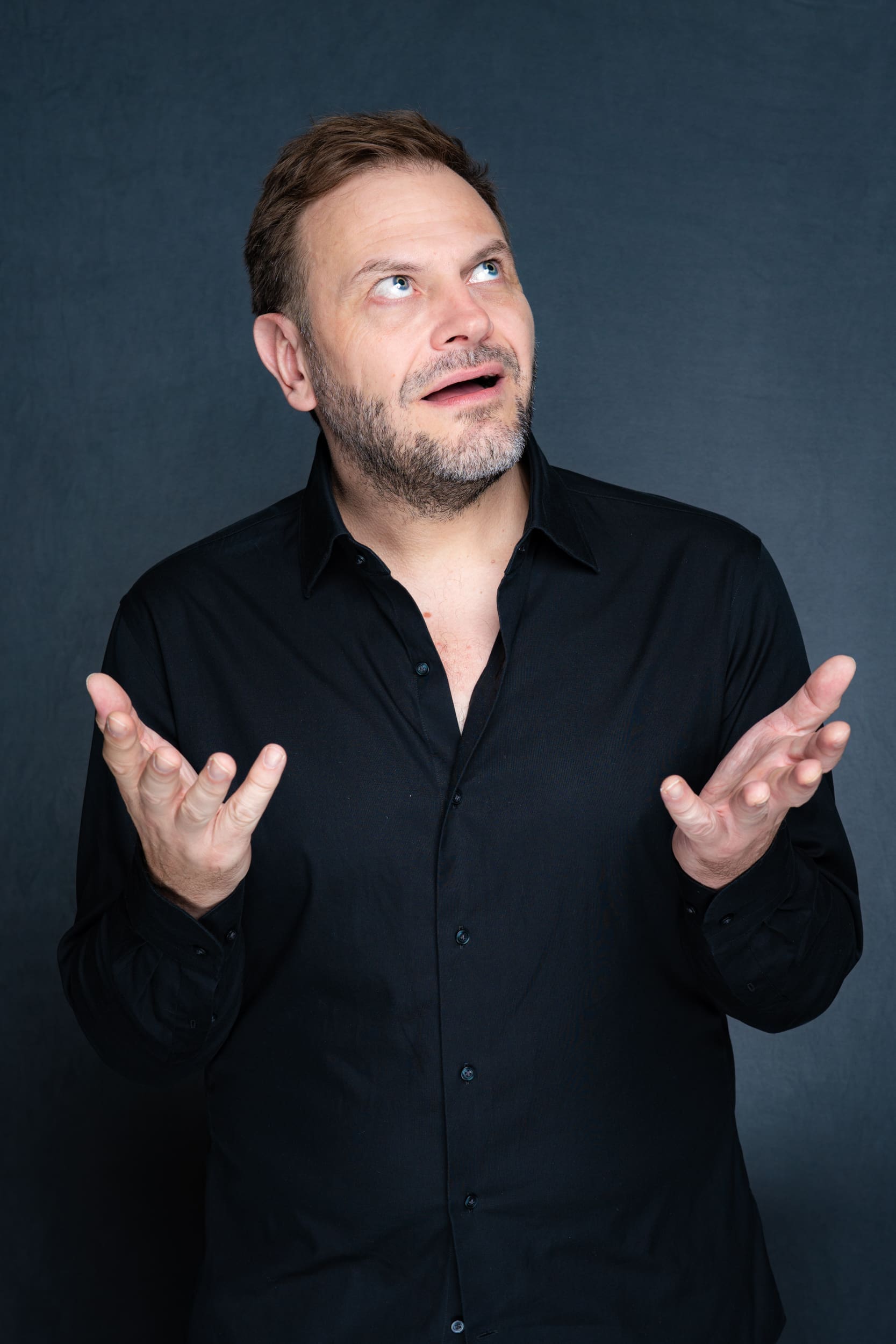 Int: Stand-up Comedian in a black shirt against a grey backdrop Portrait Photography Sydney NSW
