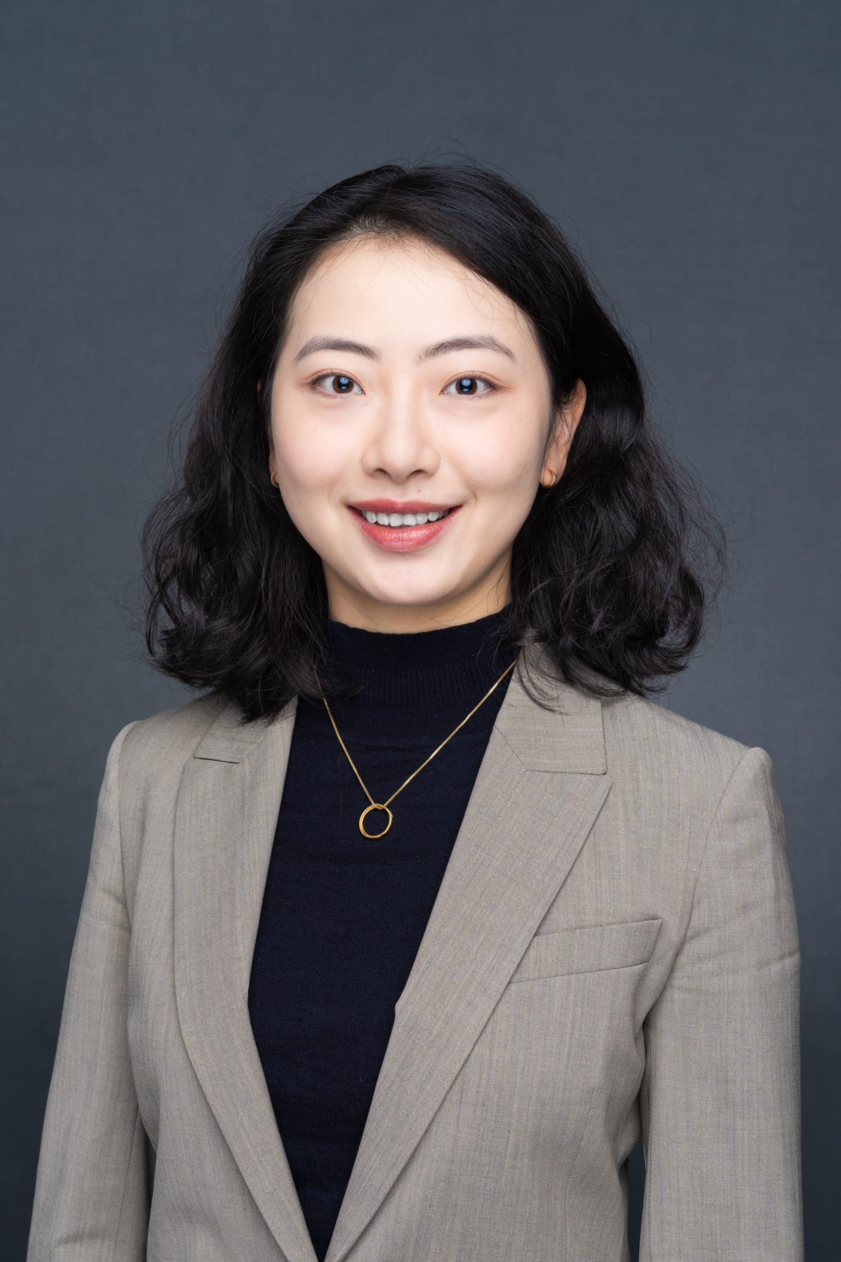 Int: Young Asian woman in a brown jacket having her Sydney Headshot taken by Photographer Georgie Greene In Sydney NSW