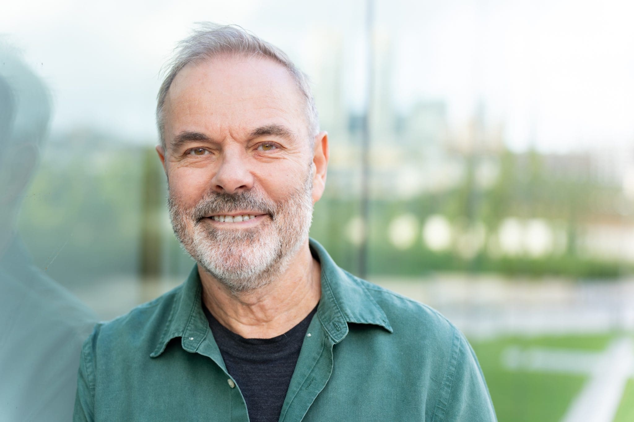 Ext: Journalist wearing a green shirt having his headshot taken by professional photographer Georgie Greene in Sydney NSW