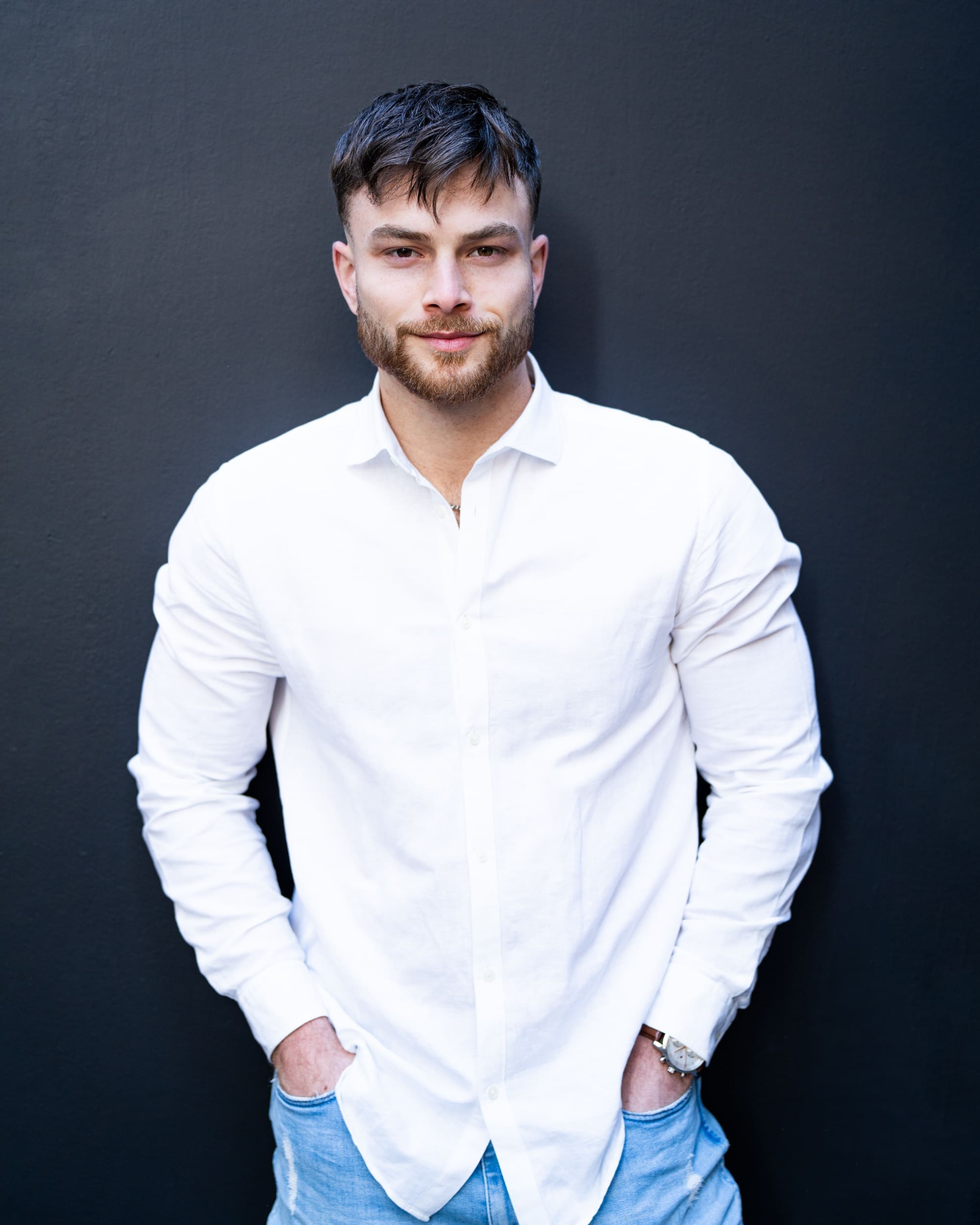 Dark haired bearded young man in white shirt having his actor headshot taken by Sydney professional photographer Georgie Greene