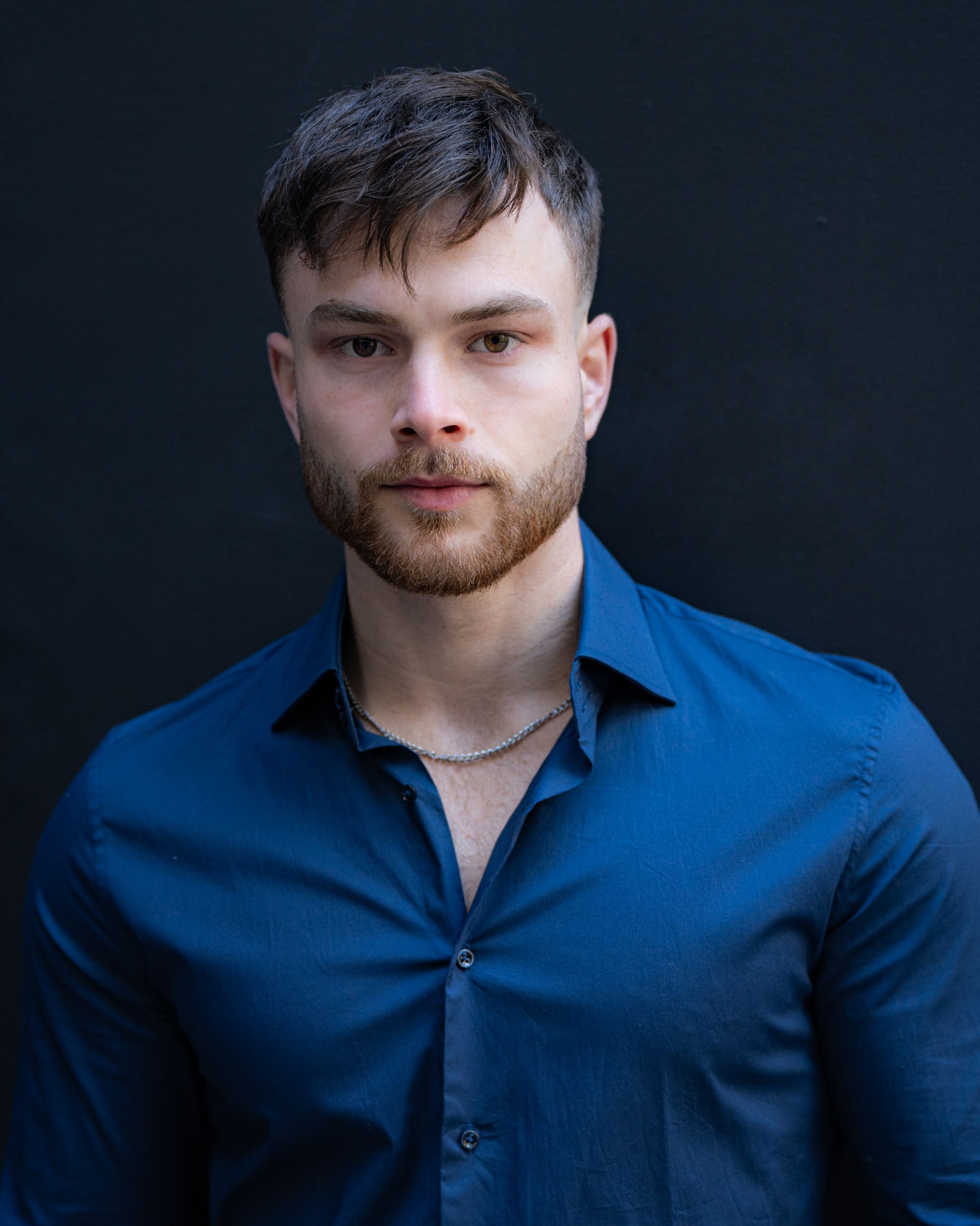 Dark haired bearded young man in blue shirt having his Sydney actor headshot taken by actor headshot photographer Georgie Greene