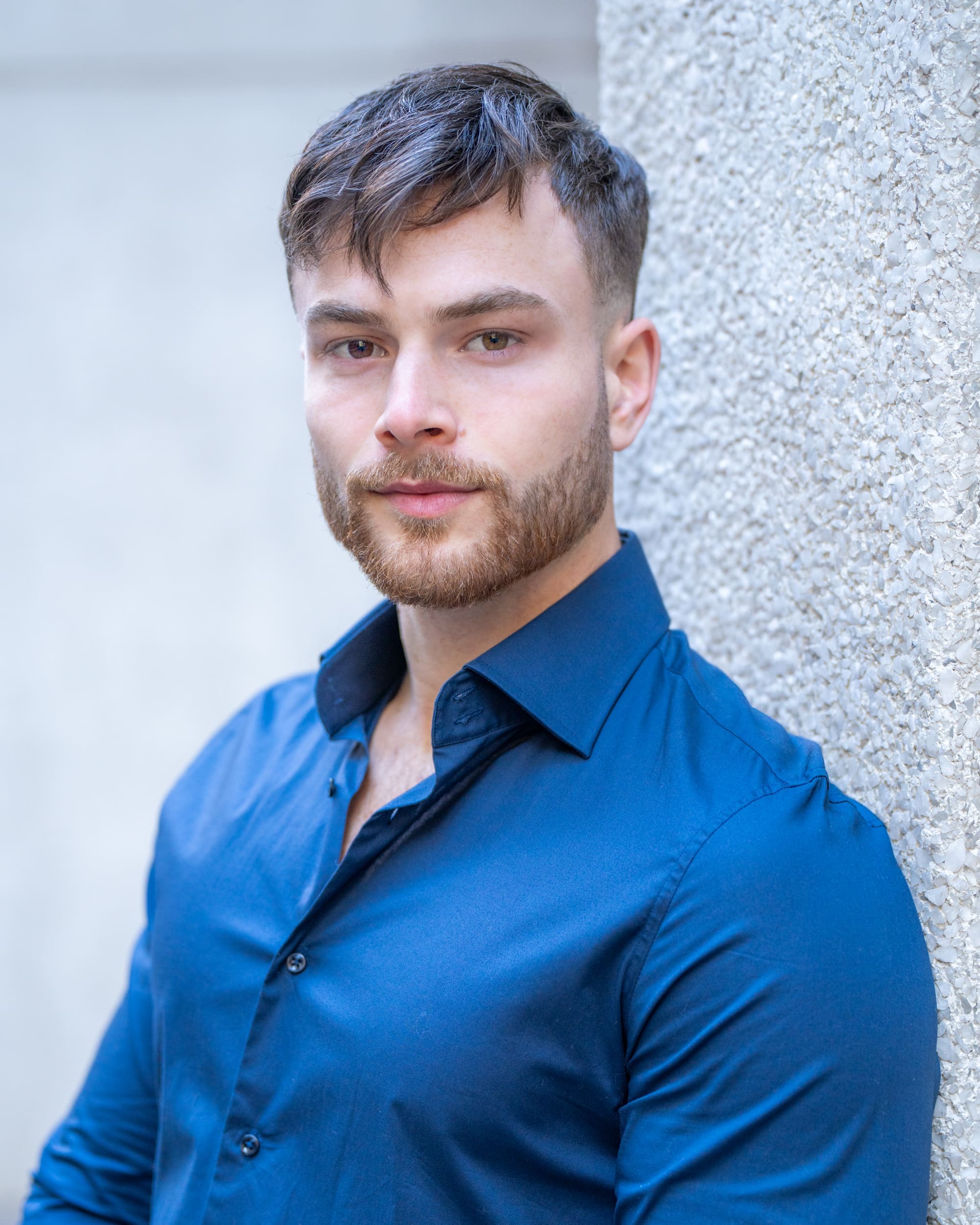 Dark haired bearded young man in blue shirt having his headshot taken by Sydney actor headshot photographer Georgie Greene