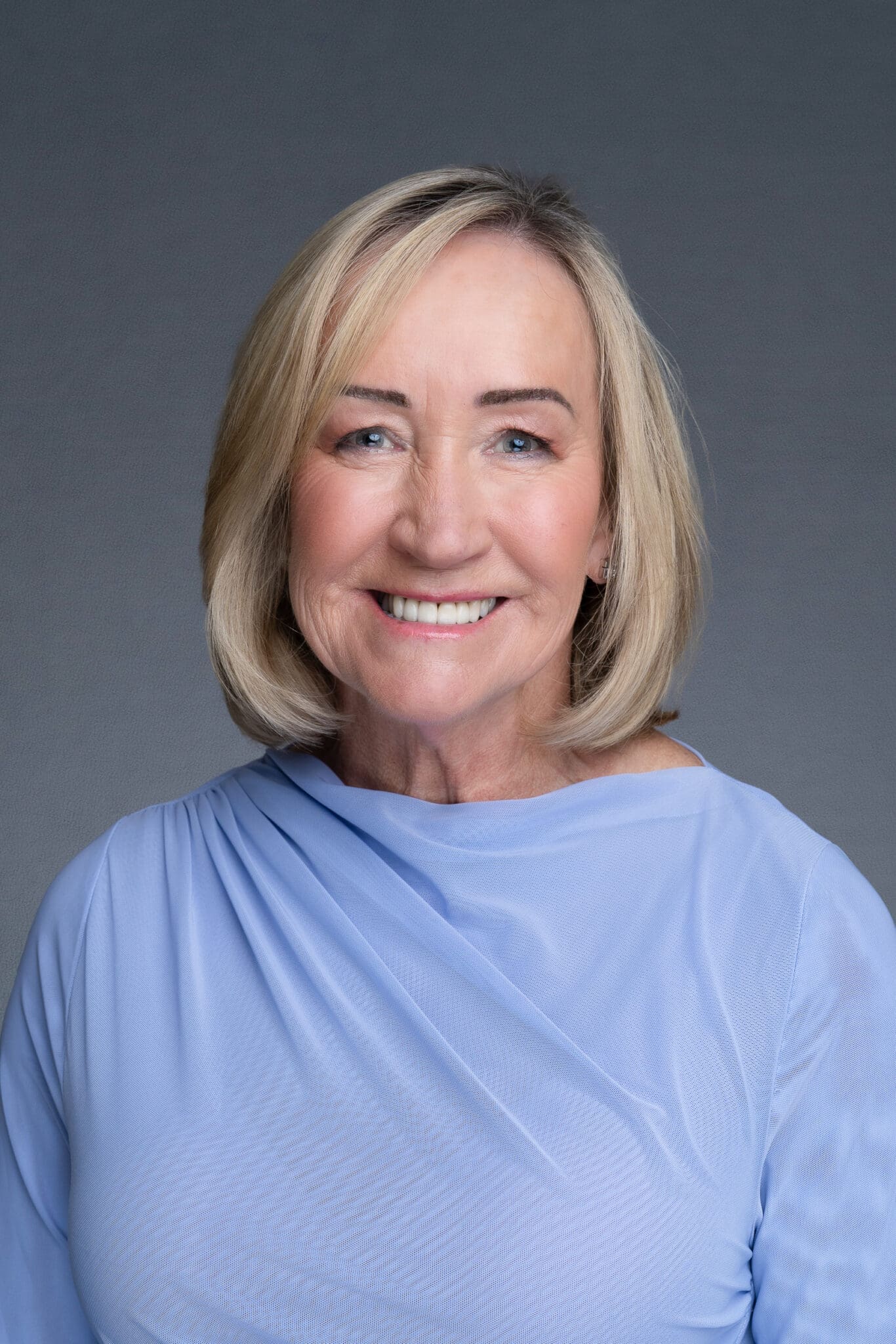 Female CEO wearing a blue shirt and having her LinkedIn headshot taken by Sydney corporate photographer Georgie Greene
