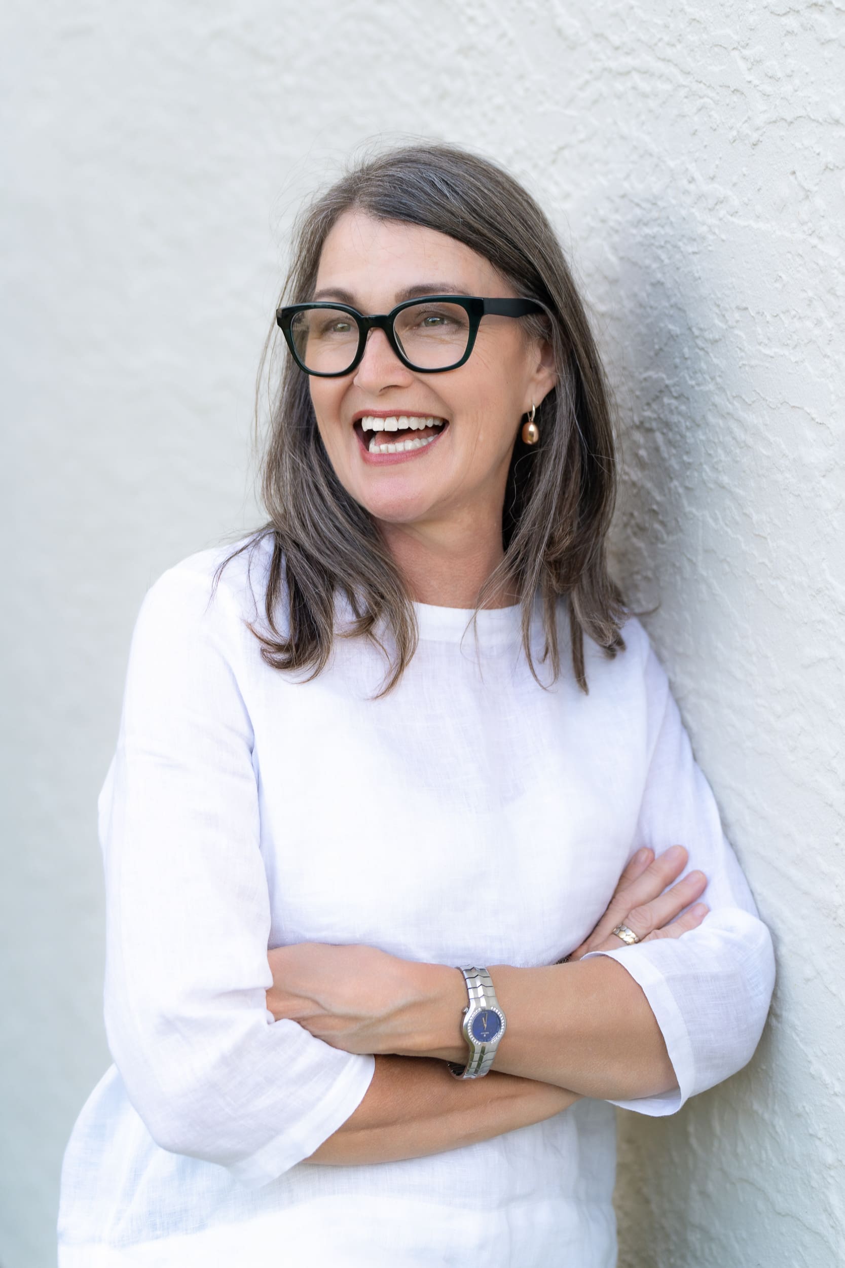 laughing woman wearing a white top having her relaxed headshot taken by Sydney headshot photographer Georgie Greene