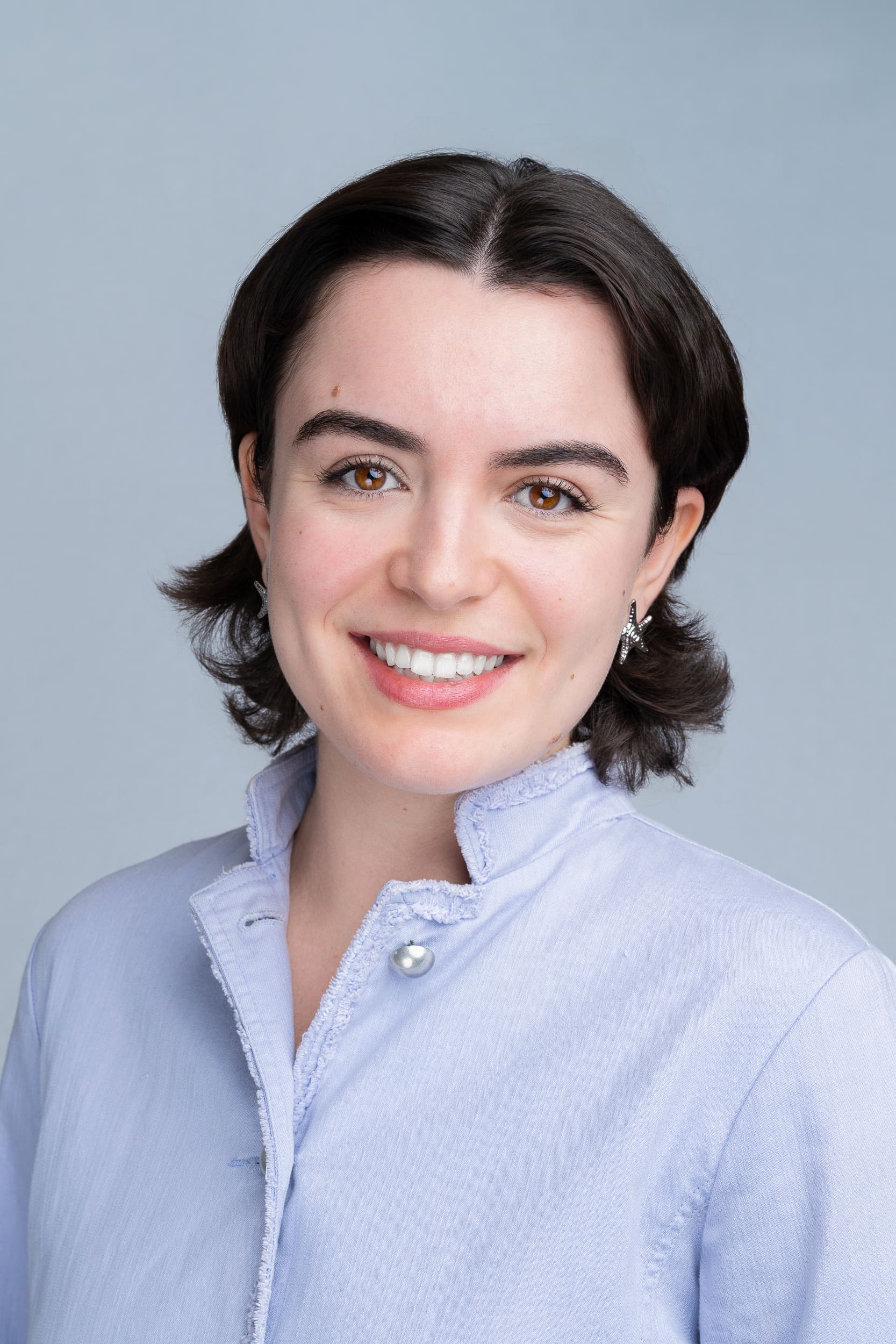 Young woman with dark hair in a blue blouse having her headshot taken by Sydney headshot photographer Georgie Greene