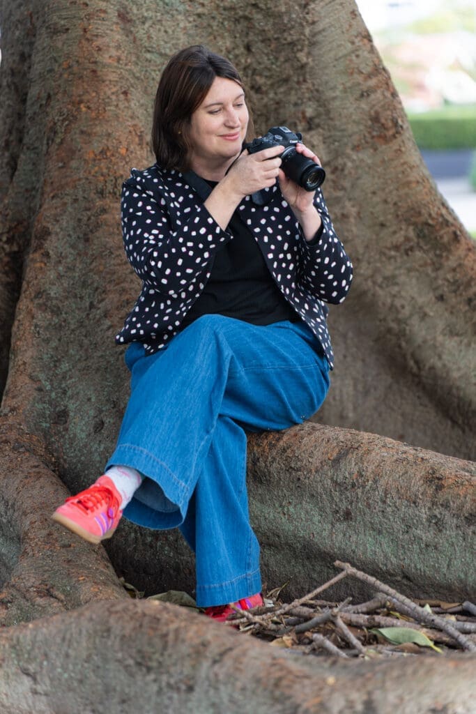 photographer in a spotty top holding a camera and having her personal branding portrait taken by Sydney professional photographer Georgie Greene