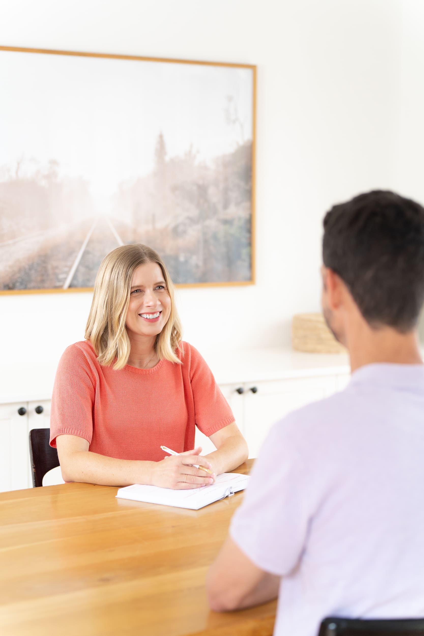 Woman in a coral top talking to a client and having her personal branding taken by Sydney personal branding photographer Georgie Greene