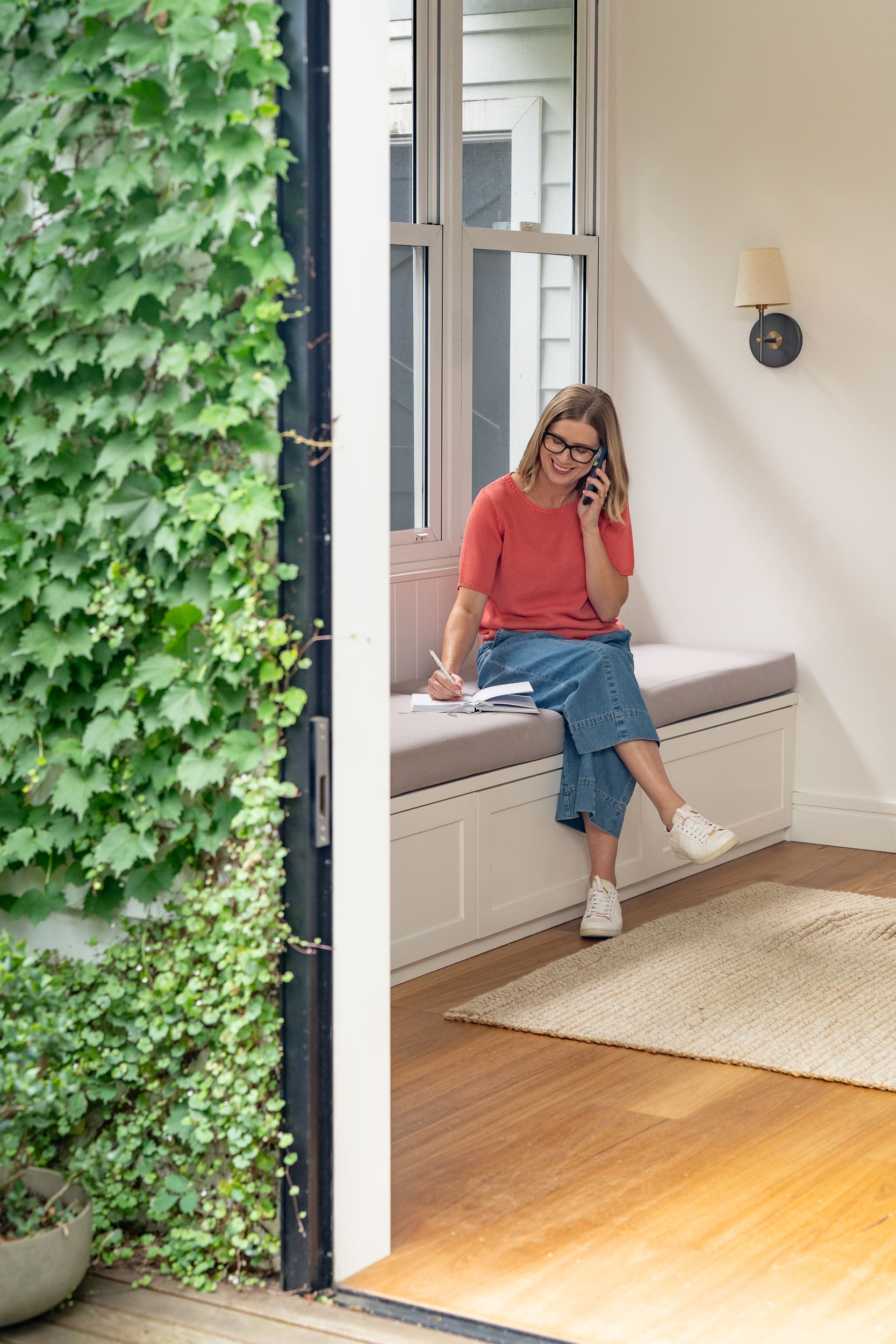 Woman in a coral top on the phone and having her personal branding taken by Sydney personal branding photographer Georgie Greene