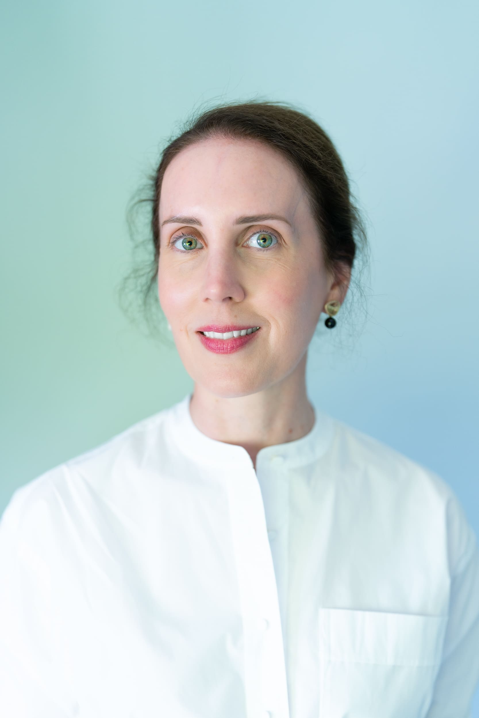 Young dark haired woman wearing white shirt and having her natural light headshot taken by professional Sydney headshot photographer Georgie Greene