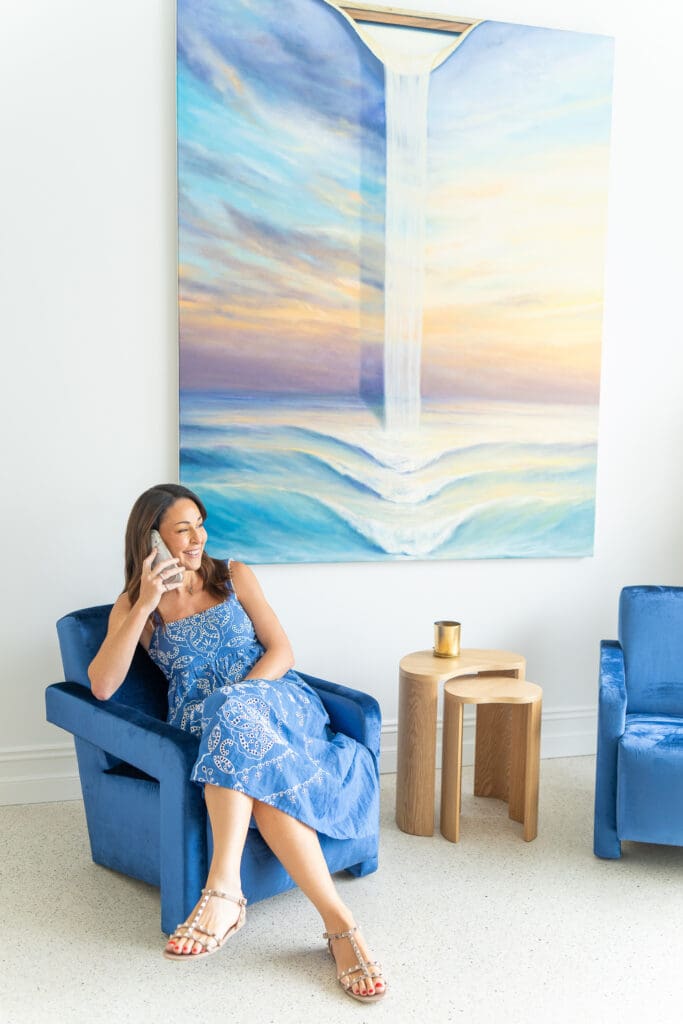 dark haired marketing specialist sitting on a blue chair on the phone having her personal branding photo taken by professional Sydney photographer Georgie Greene